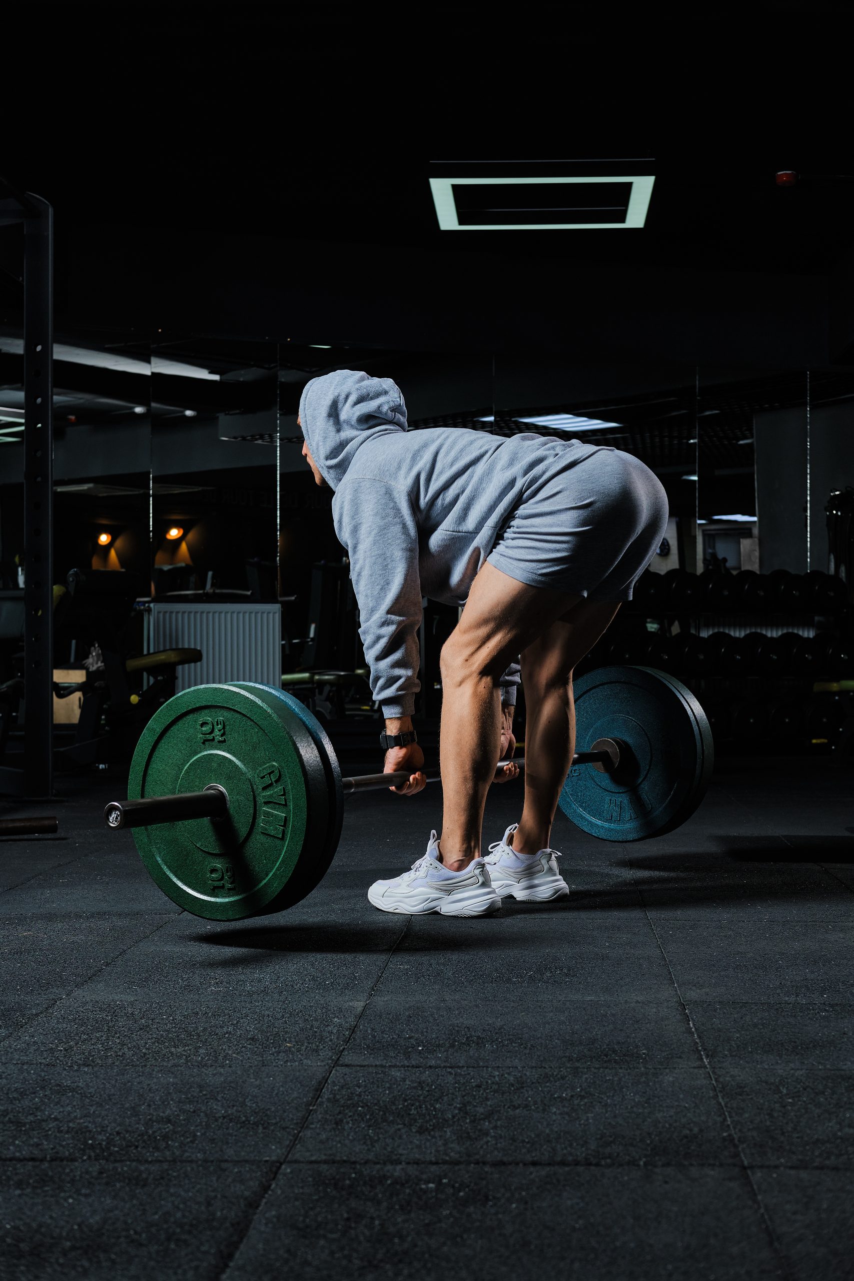 Muscular man doing deadlift exercise with barbell in gym